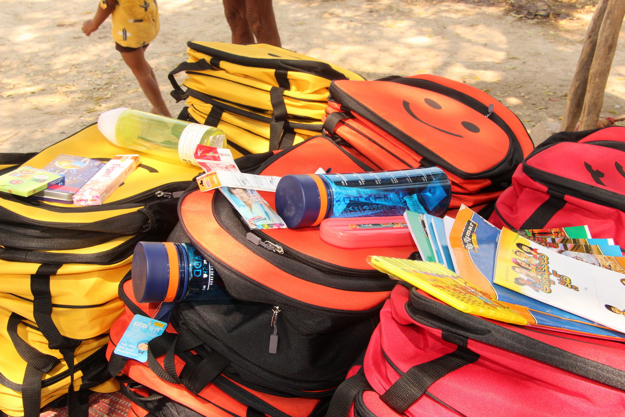 Our backpack in yellow, orange and red with a close-up of some of the essential inserts that go in each school bag