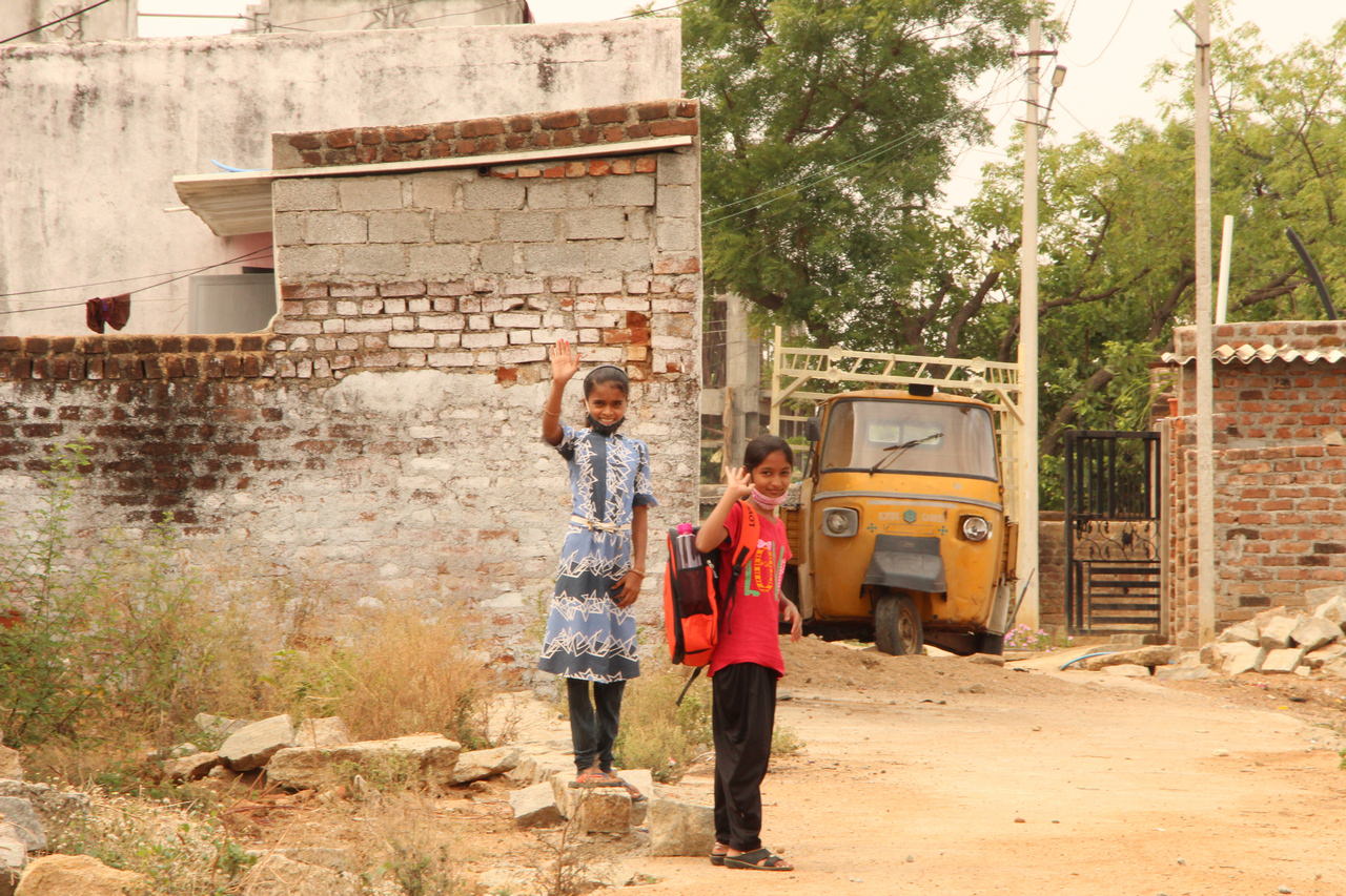 Two girls wave goodbye after the distribution